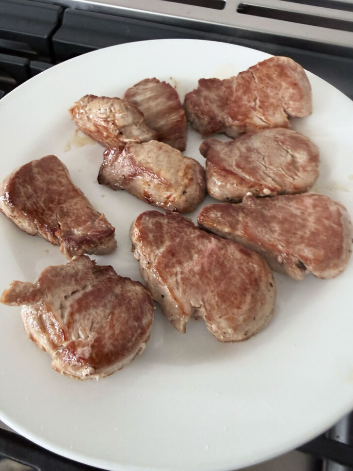 Browned pork removed to a plate.