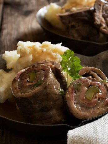 German beef rouladen sliced open in small skillet