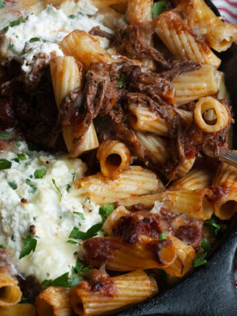 baked pasta with brisket ragu and ricotta in cast iron skillet