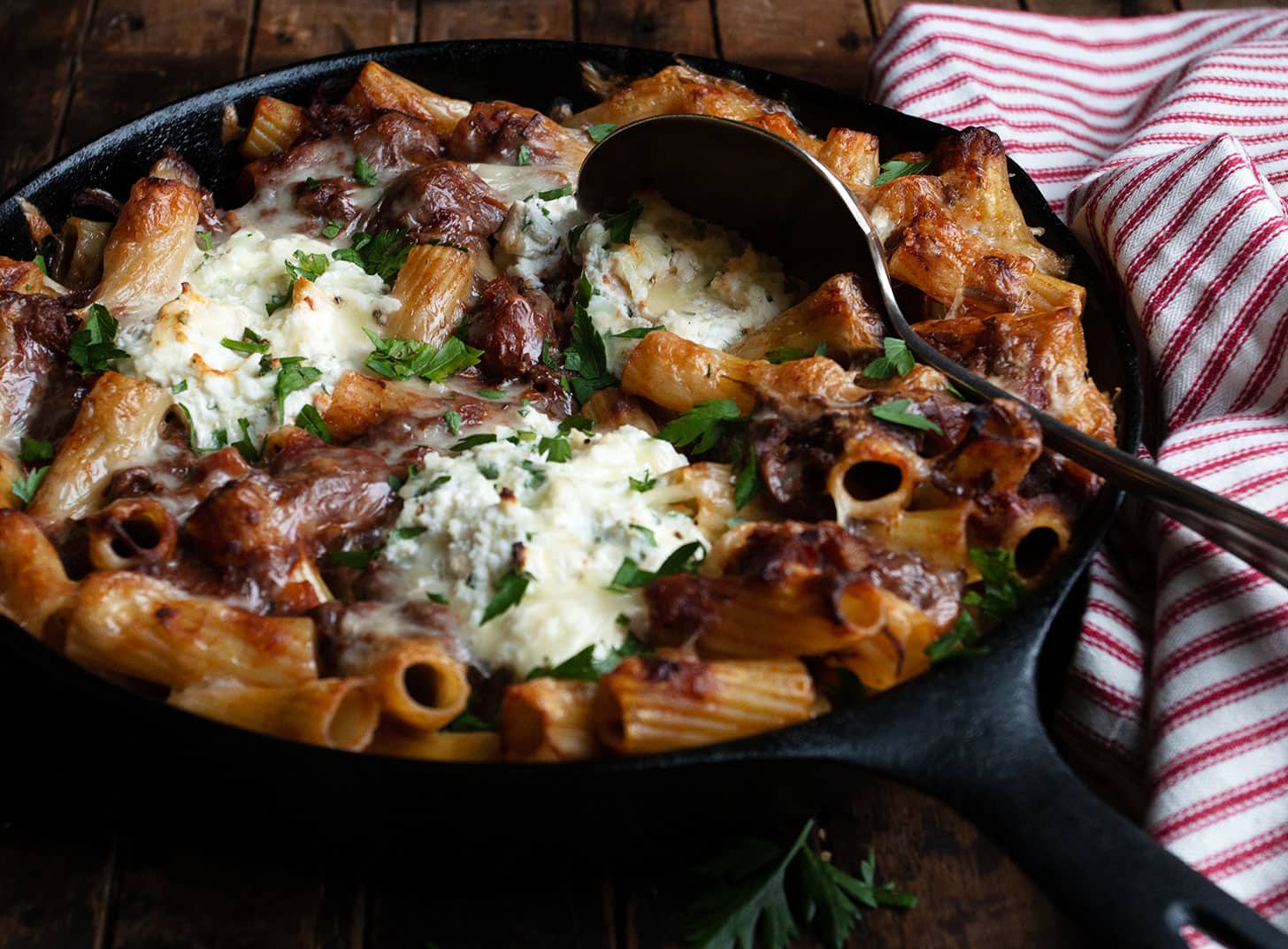 baked pasta with brisket ragu and ricotta in cast iron skillet