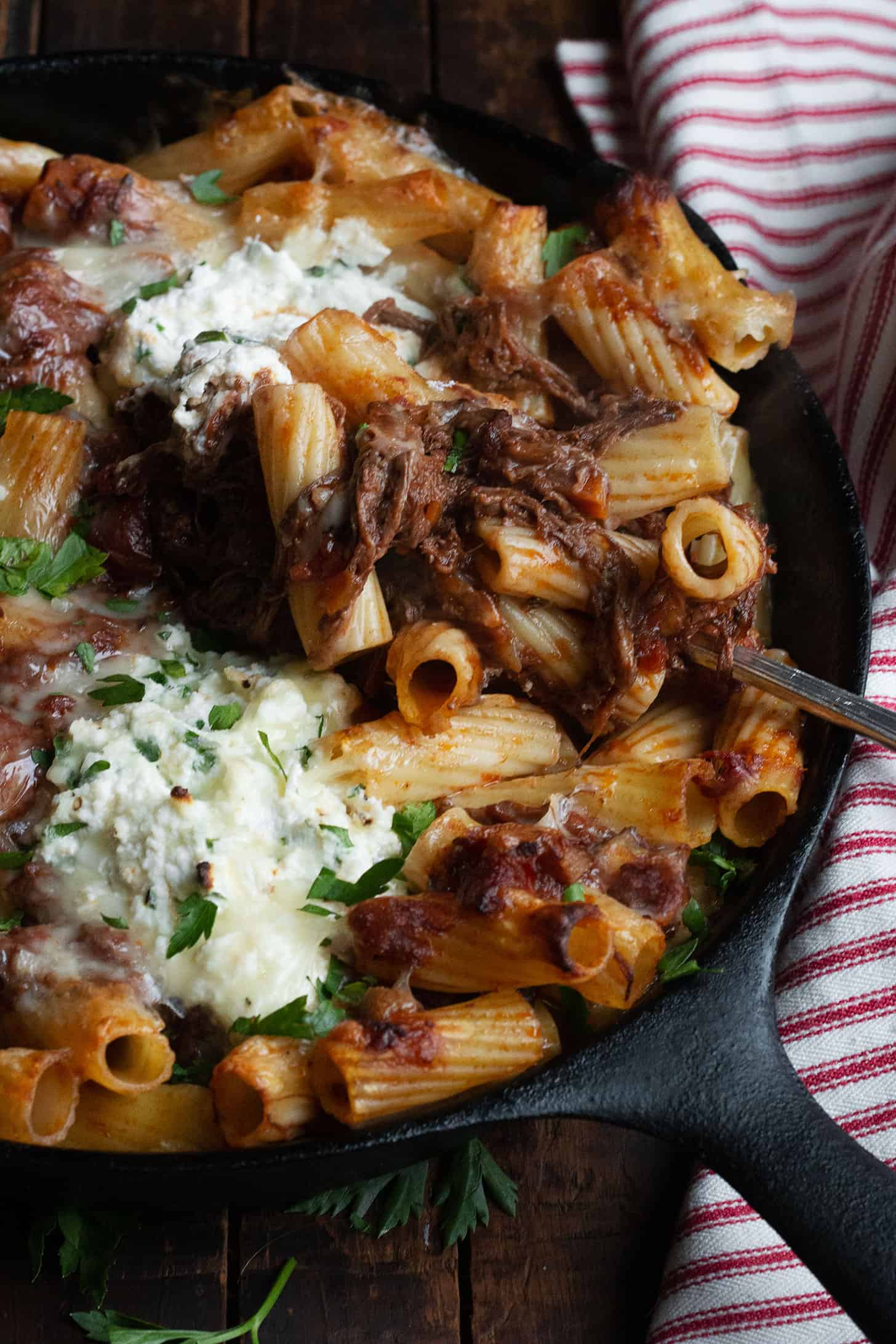 baked pasta with brisket ragu and ricotta in cast iron skillet