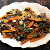 maple roasted vegetables with maple pecans on white plate