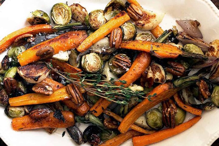 maple roasted vegetables with maple pecans on white plate