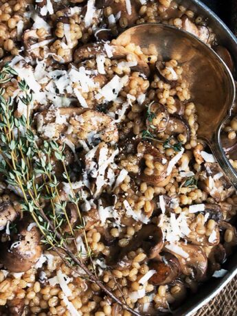 barley risotto with mushrooms in pan with spoon