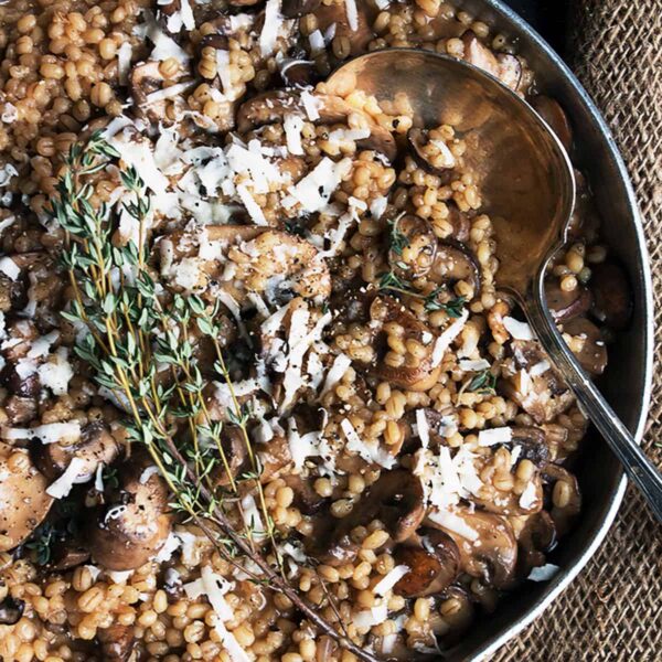 barley risotto with mushrooms in pan with spoon