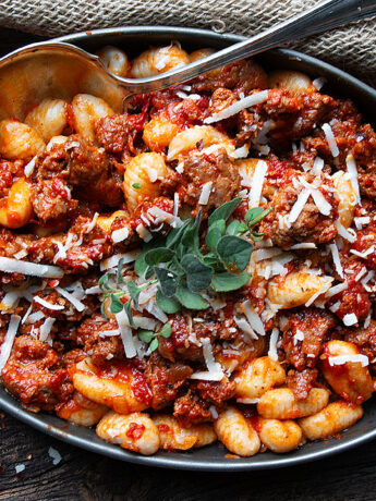 gnocchi with chorizo sausage in serving dish with spoon