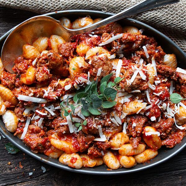 gnocchi with chorizo sausage in serving dish with spoon