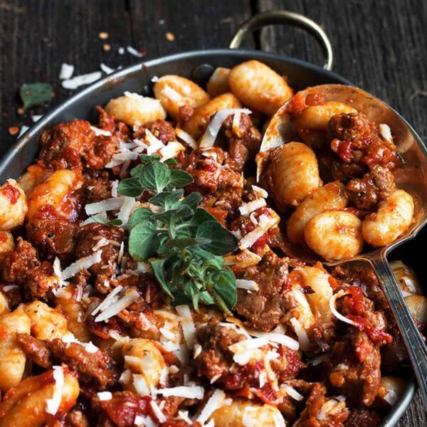 gnocchi with chorizo sausage sauce in pan with spoon