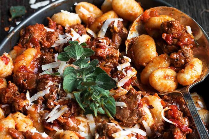 gnocchi with chorizo sausage sauce in pan with spoon
