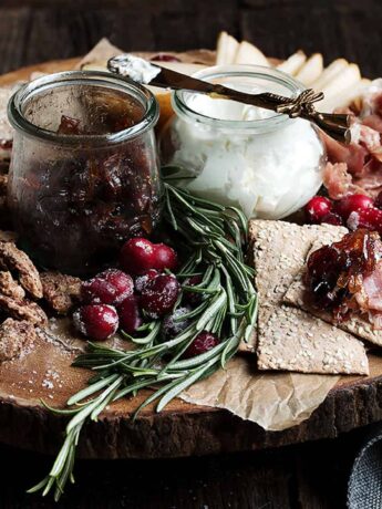 cranberry charcuterie platter on wooden round board