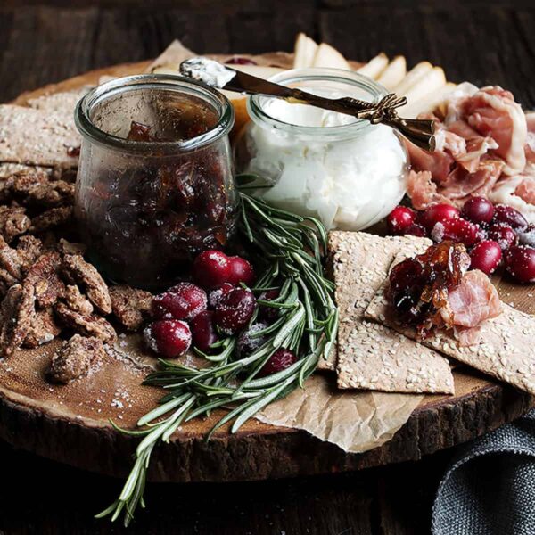 cranberry charcuterie platter on wooden round board