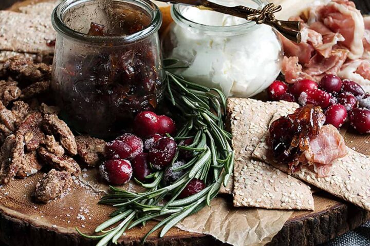 cranberry charcuterie platter on wooden round board
