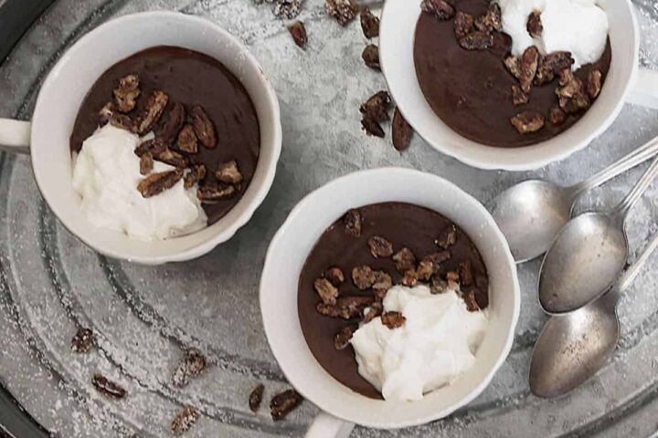 warm chocolate pudding in small cups on tray with spoon