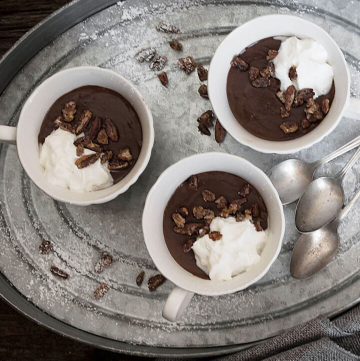 warm chocolate pudding in small cups on tray with spoon