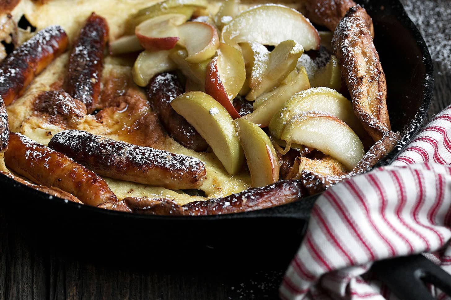 sausage Dutch baby pancake with apples in skillet
