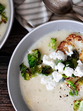 cauliflower potato soup in bowl with goat cheese crumbles