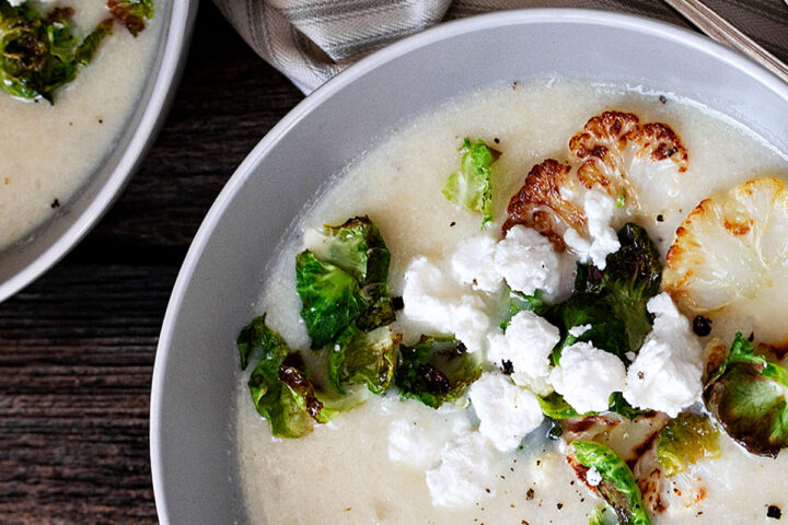 cauliflower potato soup in bowl with goat cheese crumbles