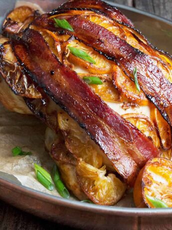 hoisin roasted whole chicken on platter with oranges