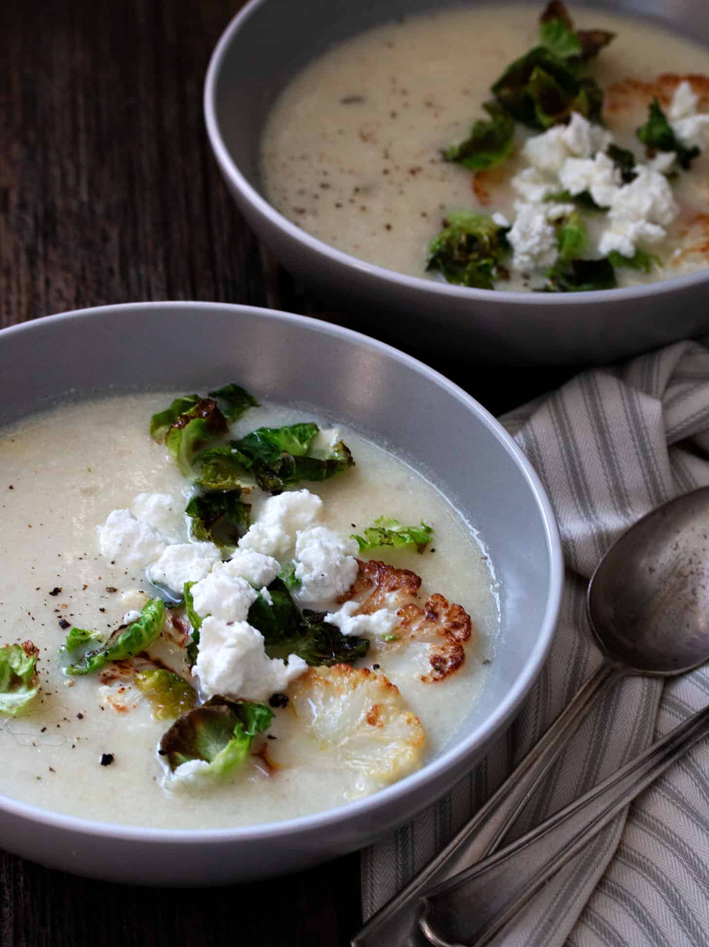 cauliflower potato soup in bowl with goat cheese crumbles
