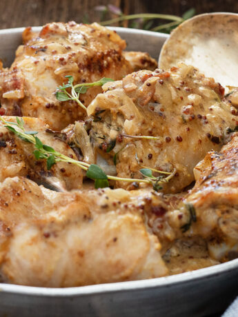chicken dijon in baking dish with spoon