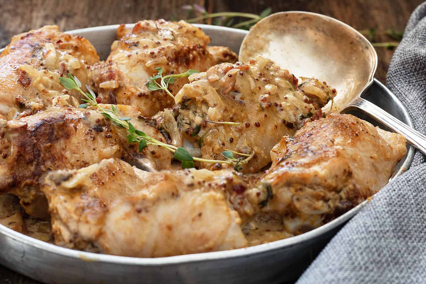 chicken dijon in baking dish with spoon