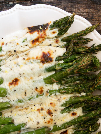 Asparagus cacio e pepe on a white serving platter.