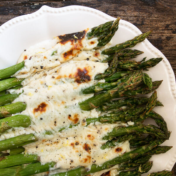 Asparagus cacio e pepe on a white serving platter.