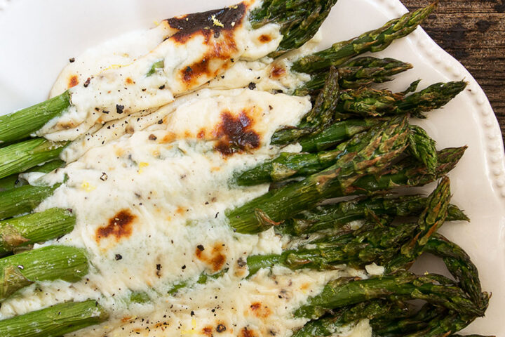Asparagus cacio e pepe on a white serving platter.
