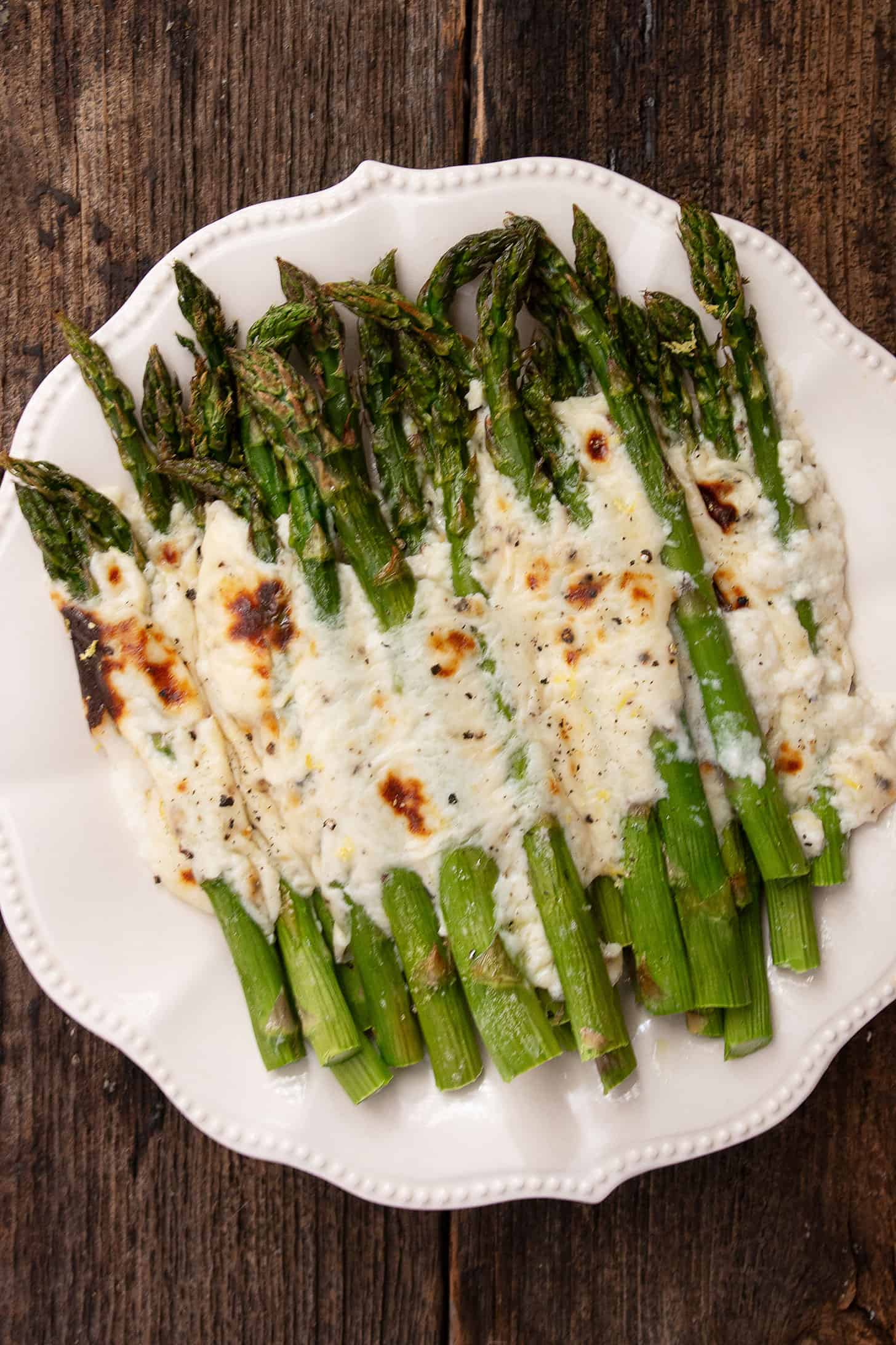 Asparagus cacio e pepe on a white serving platter.