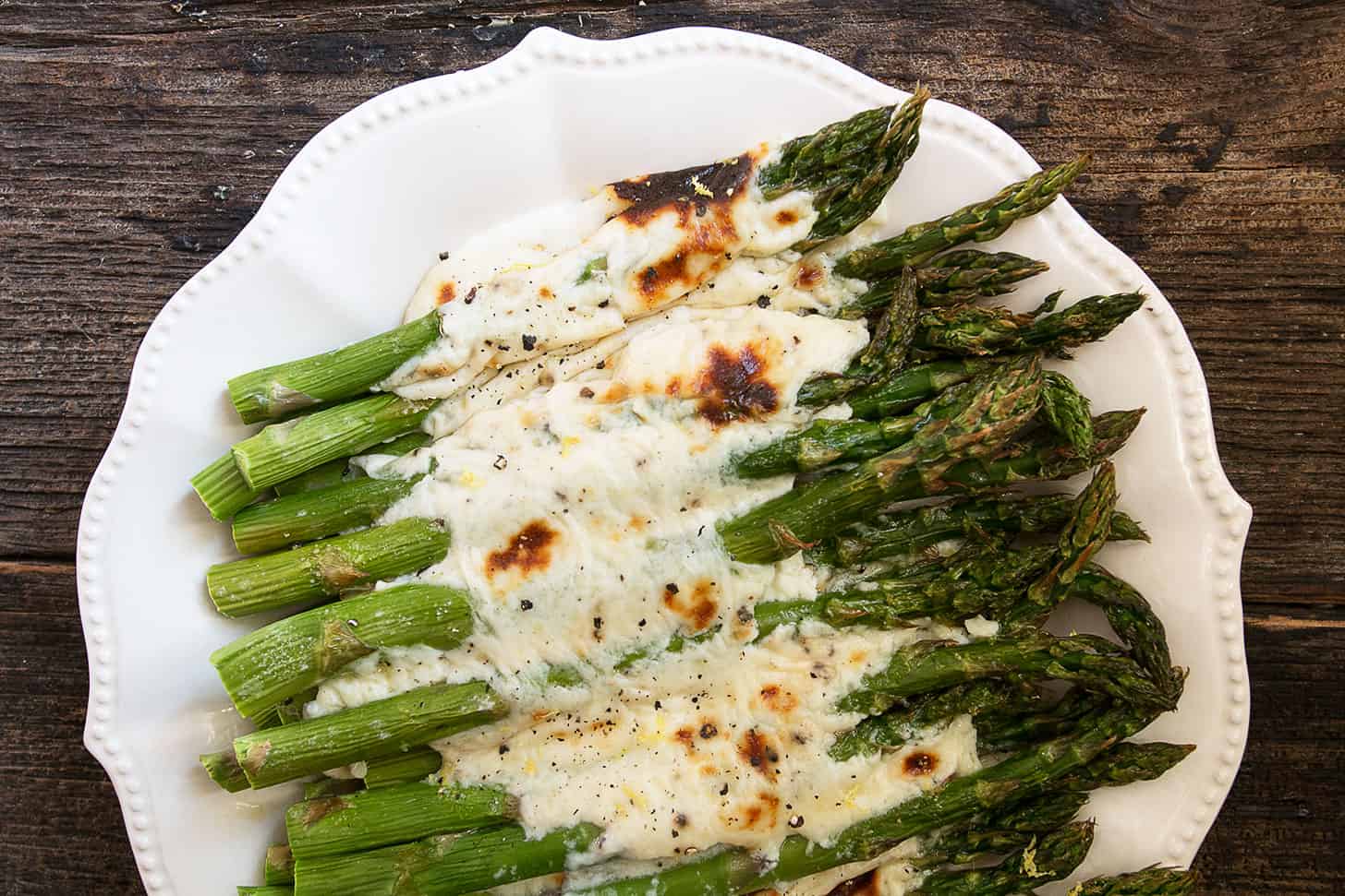 Asparagus cacio e pepe on a white serving platter.