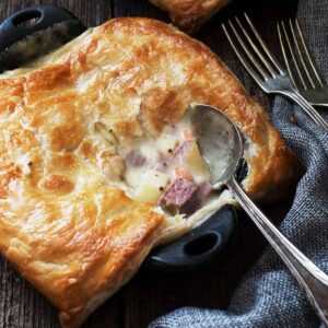 corned beef and cabbage pot pies in small cast iron skillets with spoon