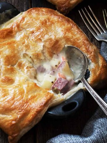 corned beef and cabbage pot pies in small cast iron skillets with spoon