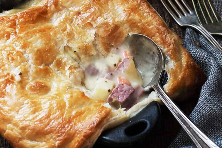 corned beef and cabbage pot pies in small cast iron skillets with spoon