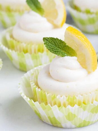 lemon cupcakes with lemon slice and mint sprig on top