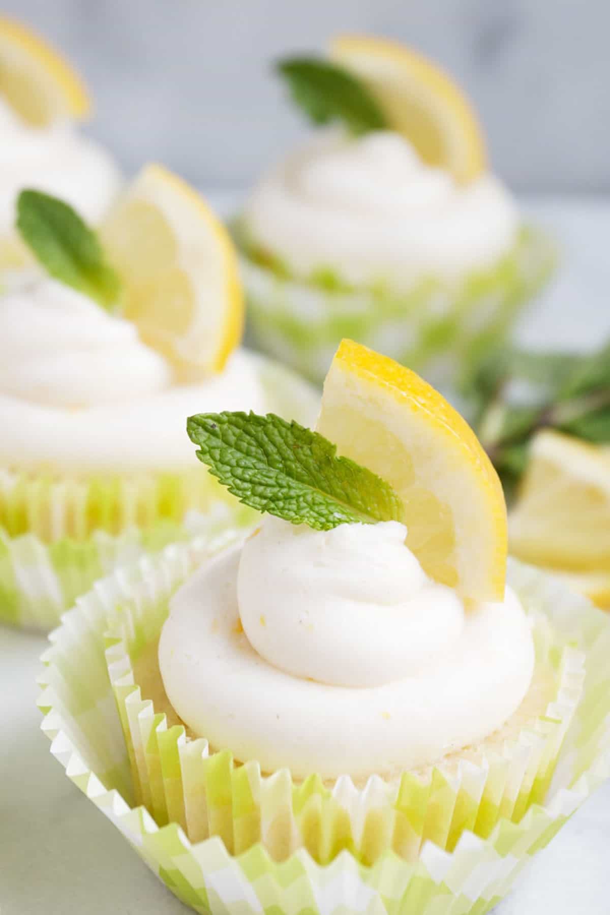 lemon cupcakes with lemon slice and mint sprig on top