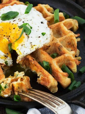 loaded potato waffles in skillet with fried egg on top