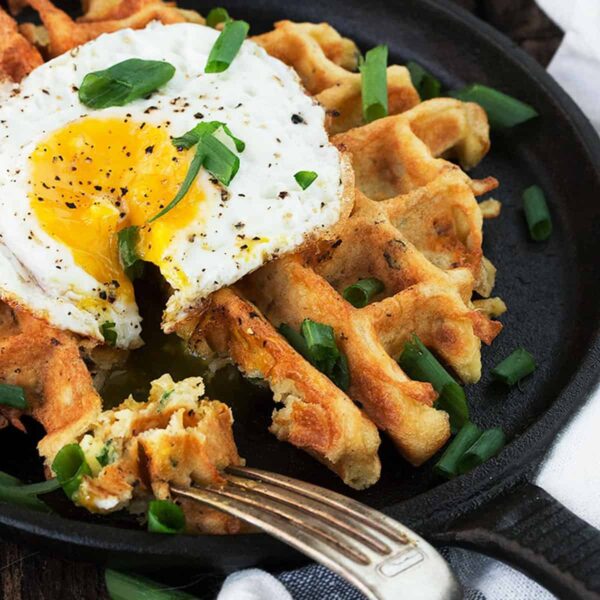 loaded potato waffles in skillet with fried egg on top