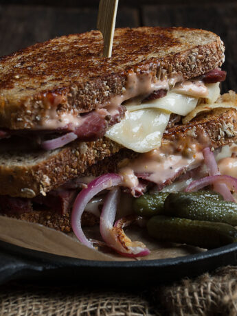 classic Reuben Sandwich on plate with pickles