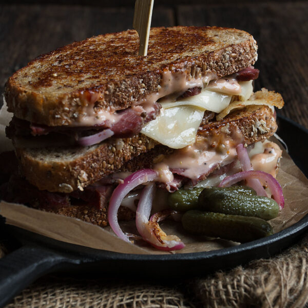 classic Reuben Sandwich on plate with pickles