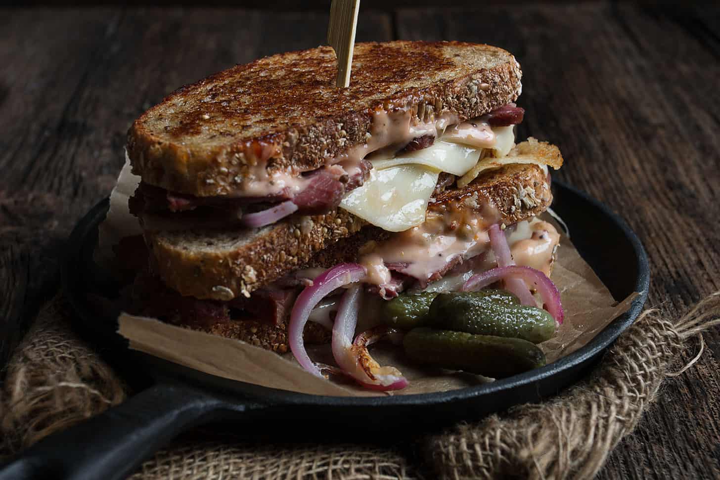 classic Reuben Sandwich on plate with pickles