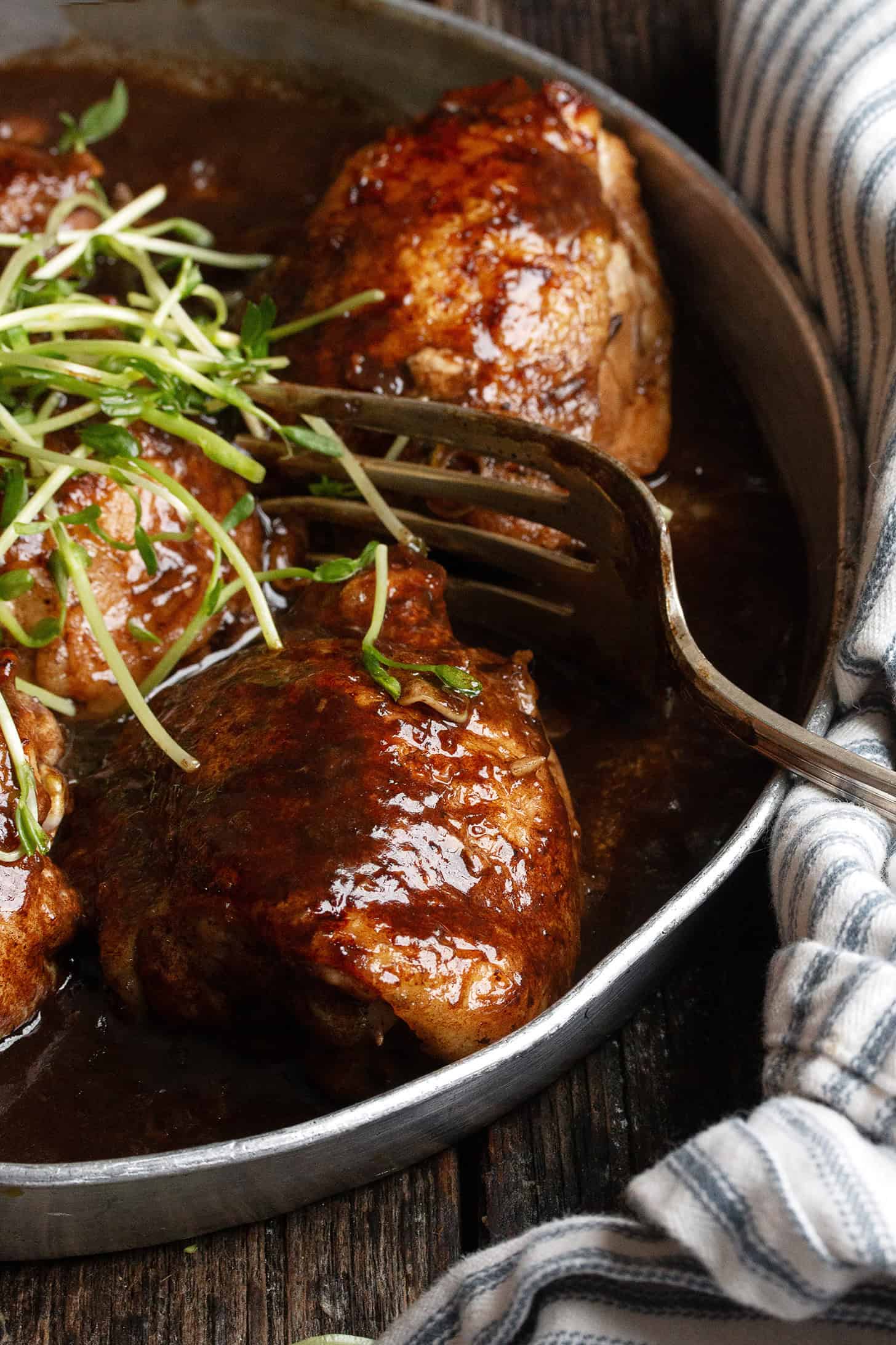 Balsamic chicken thighs on a serving plate.