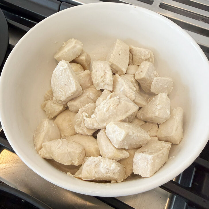 Cooked chicken pieces removed to a bowl.