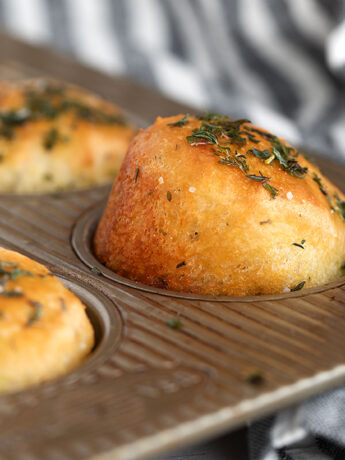 Herb focaccia muffins in muffin tin.
