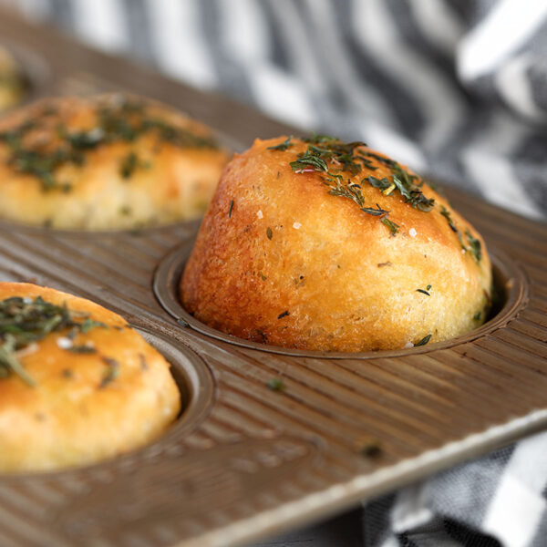 Herb focaccia muffins in muffin tin.