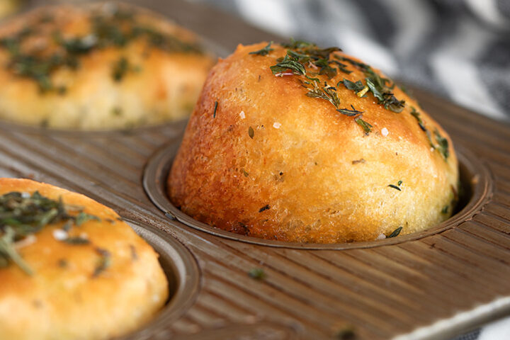 Herb focaccia muffins in muffin tin.