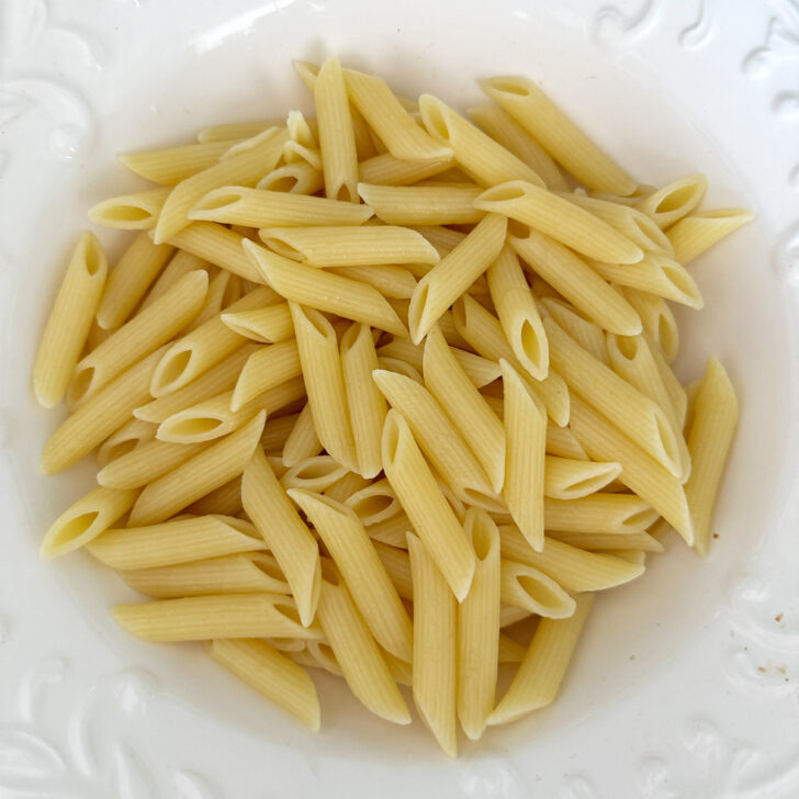 Cooked pasta added to a large salad bowl.