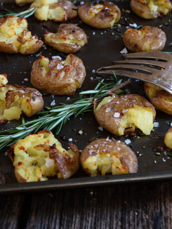rosemary olive oil smashed potatoes on baking sheet
