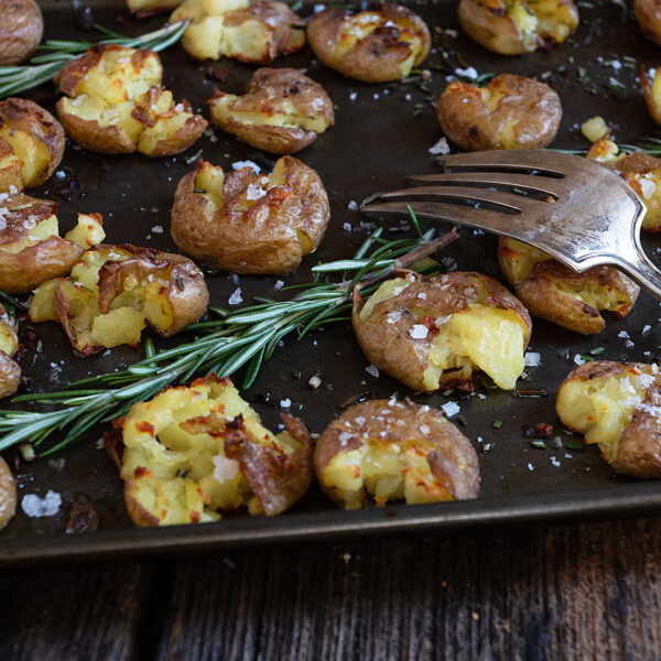 rosemary olive oil smashed potatoes on baking sheet