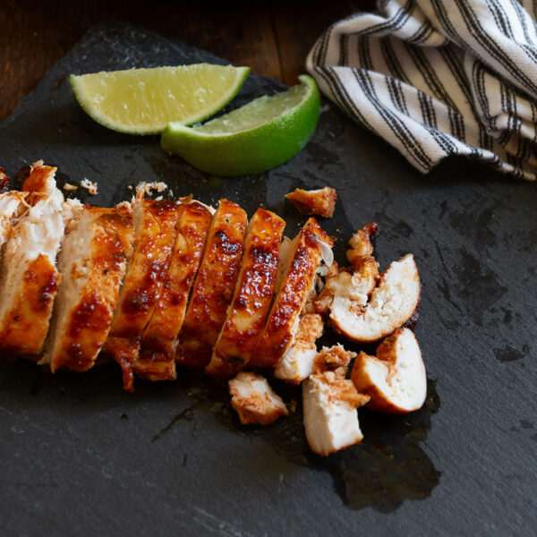 Chili lime chicken sliced on a cutting board.