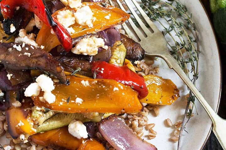 farro and roasted vegetable salad on white plate with fork